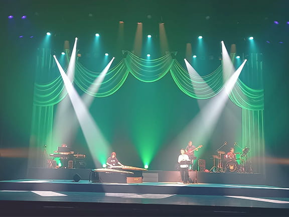 スポットで照らされるステージで演奏する演者